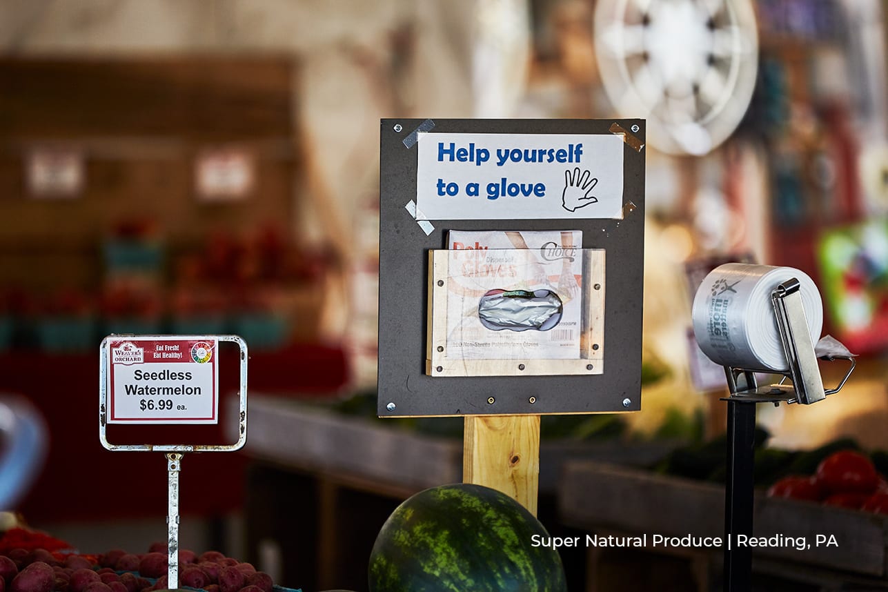 sign saying 'help yourself to a glove' at super natural produce store in reading, pa