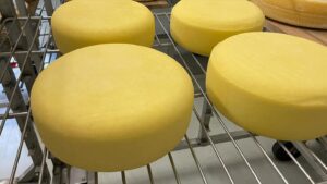 Wheels of cheese on a rack